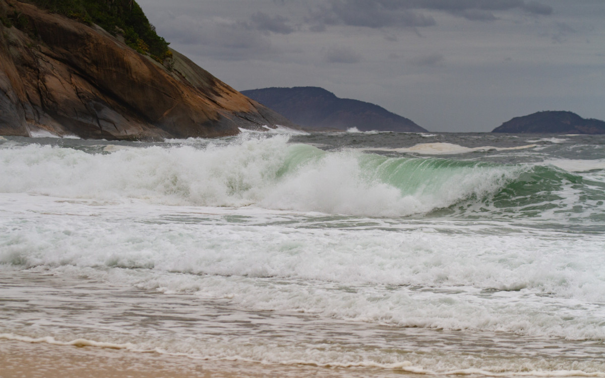 Clima ameno e mar agitado não afastam visitantes, e orla do Rio segue com movimento ao longo do dia.